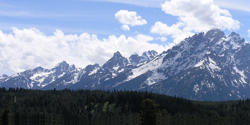 Peaks of the Teton Range form jagged spires. The park’s highest peak, the Grand Teton, is veiled by clouds.